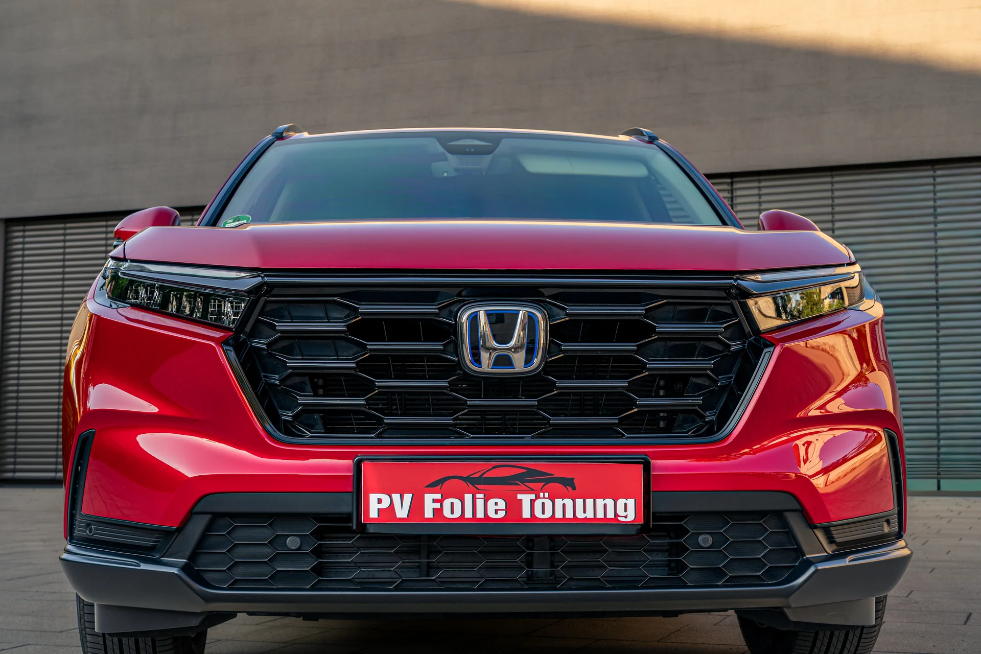 Frontansicht eines roten Honda CR-V mit PV Folie Tönung Kennzeichenblende