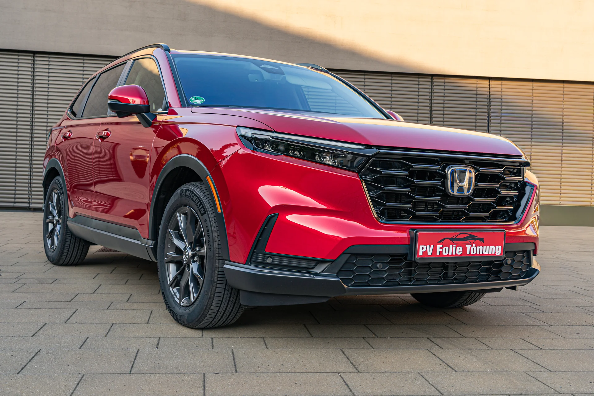 Roter Honda CR-V mit professionell getönten hinteren Scheiben in Seitenansicht